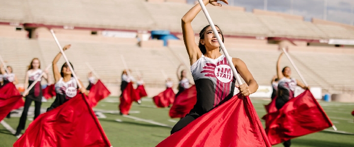 NMSU's Color Guard team, twirling bright red flags