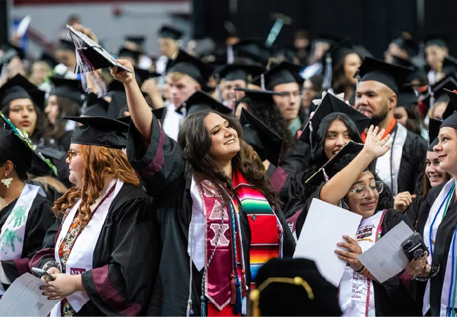 A group of grads in their cap and gown during commencement.